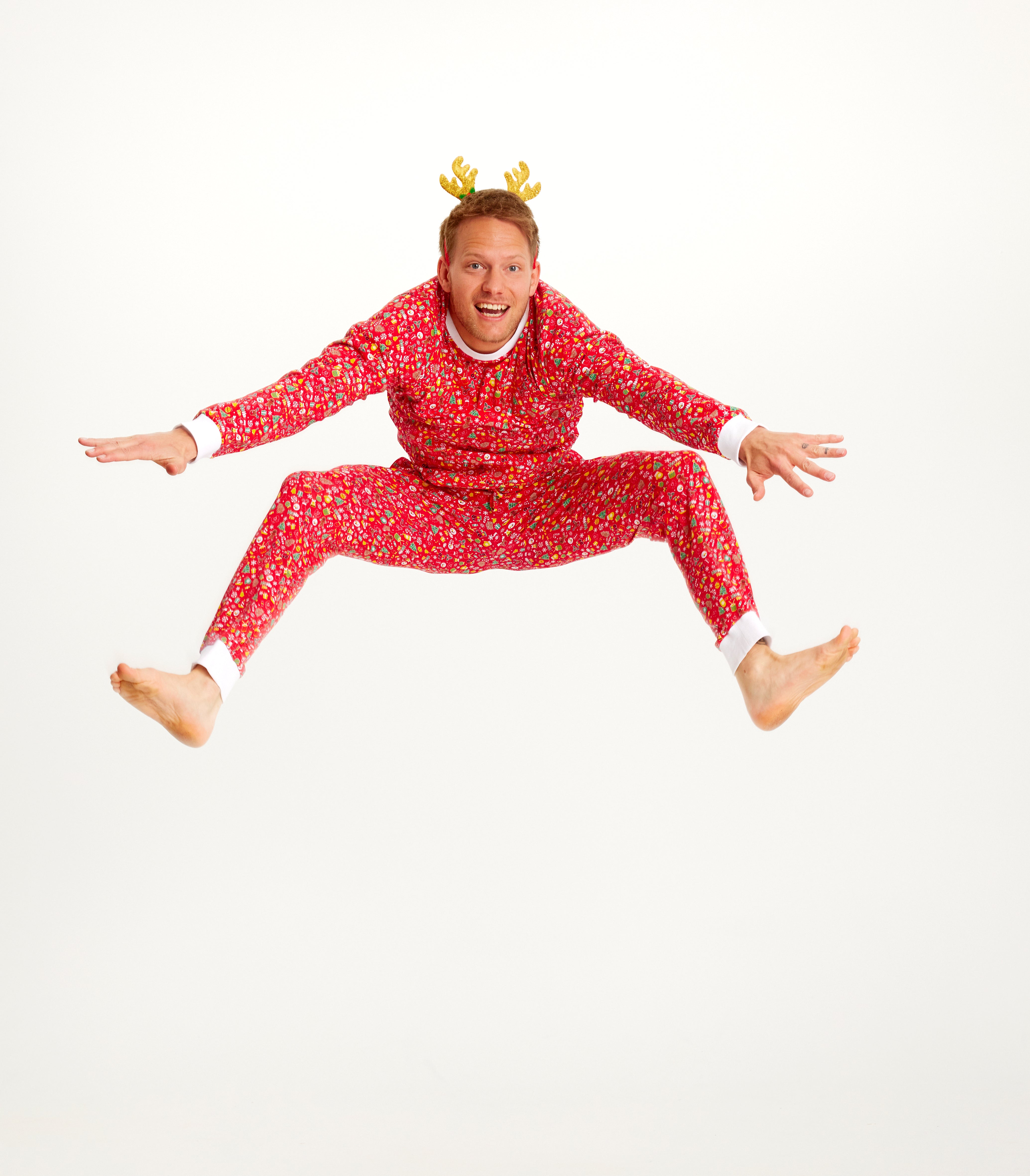 Un homme sautillant portant un pyjama de Noël rouge.